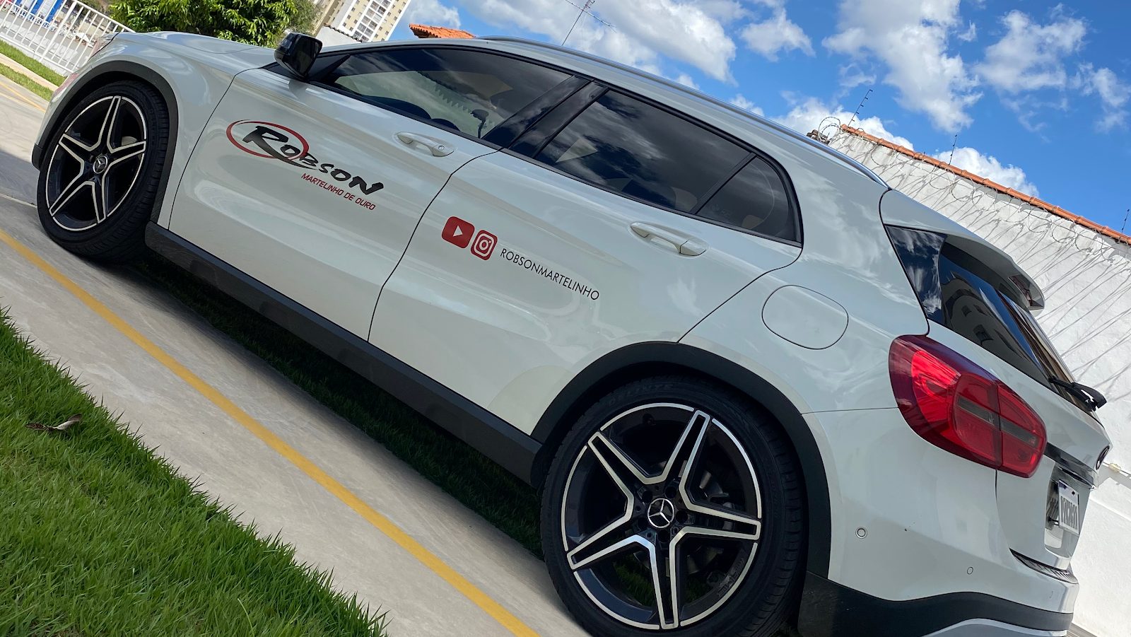 Carro branco da empresa com a marca Robson Martelinho de Ouro na lateral